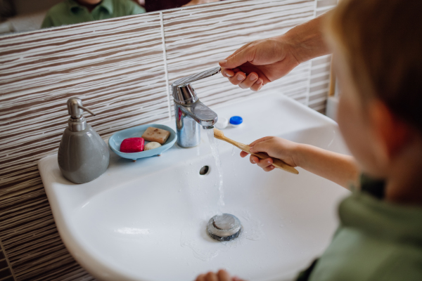 Father helping brush boy's teeth in the morning. Morning dental hygiene, care.