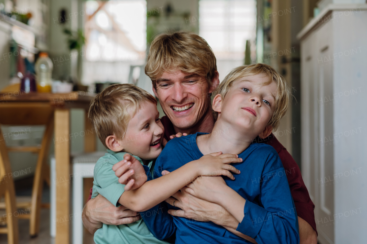 Two sons kissing father's cheeks affectionately. Concept of Father's Day, and fatherly love. Real family, real people.