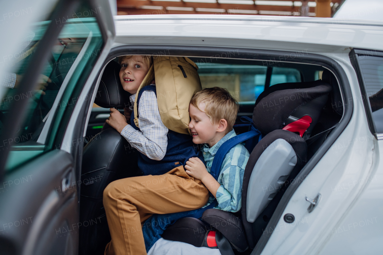 Children getting into the car, father is taking them to school and kindergarten before going to work.