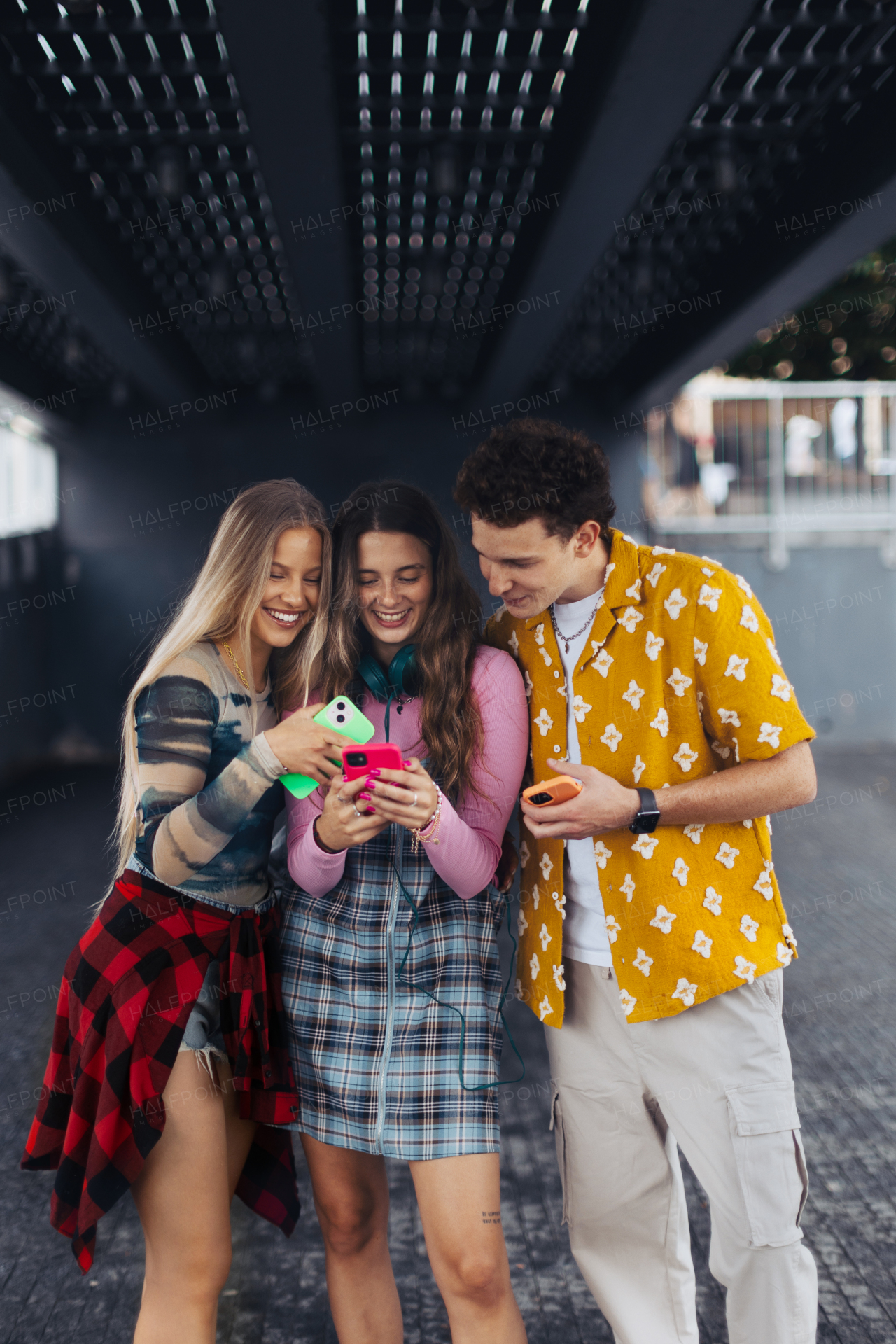 Generation z students hanging out together outdoors in the city. Young stylish zoomers are online, using smartphones, social media, taking selfies. Concept of power of friendship and social strength of gen Z.