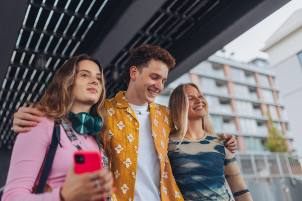 Generation z students hanging out together outdoors in the city. Concept of power of friendship and social strength of gen Z. Low angle shot with copy space.