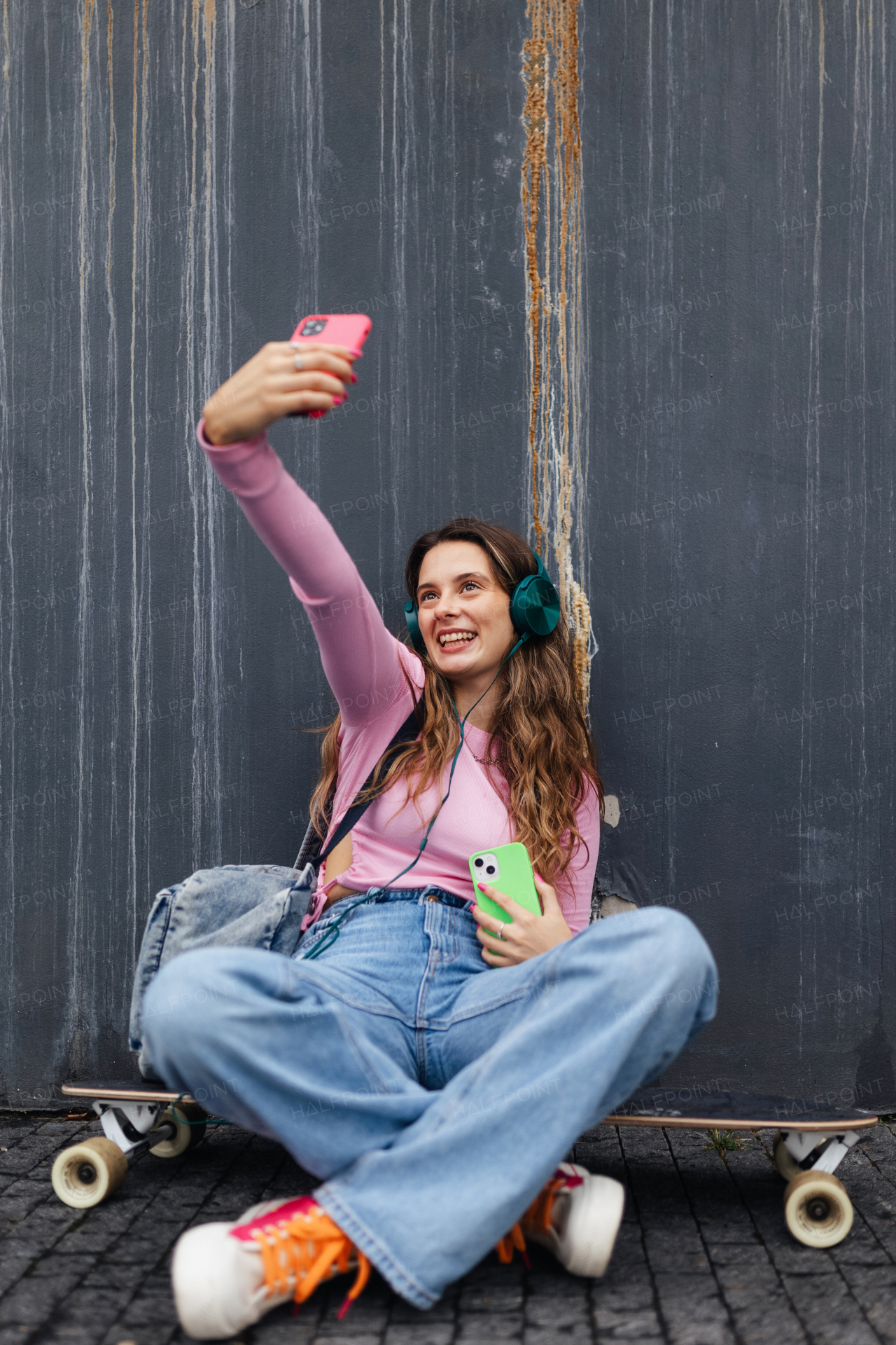 Portrait of generation z girl student sitting outdoors in the city and taking selfie. Student spending free time online and alone. Concept of gen Z as loneliest generation.