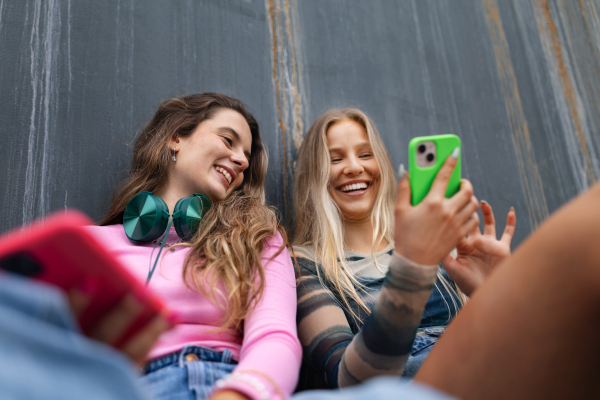 Young stylish generation Z girls spending time outdoors after school. Zoomer students talking and gossiping during lunch break in the school. Concept of power of friendship and importance of education for gen Z.