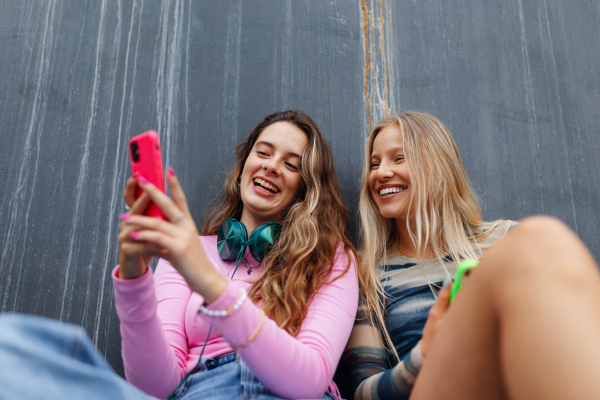 Young stylish generation Z girls spending time outdoors after school. Young female zoomers talking and gossiping during lunch break in the school. Concept of power of friendship and importance of education for gen Z.