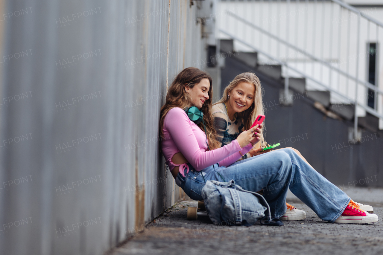 Young stylish generation Z girls spending time outdoors after school. Young female zoomers talking and gossiping during lunch break in the school. Concept of power of friendship and importance of education for gen Z.