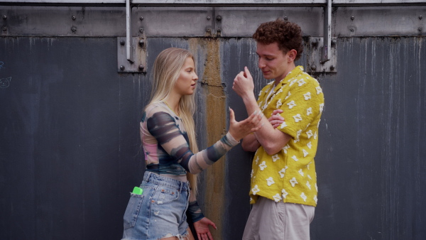 Gen Z couple having an argument outdoors in the city. Modern-day relationship problems among young peope.