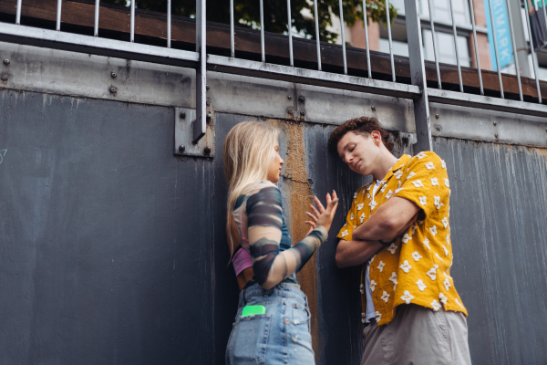 Gen Z couple having an argument outdoors in the city. Modern-day relationship problems among young peope.