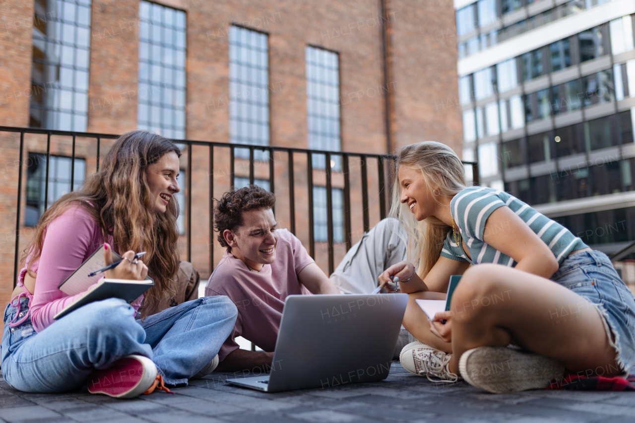 Group of generation Z students studying together after lecture on campus. Young stylish zoomers working together on school project, preparing a presentation. Concept of power of friendship and importance of education of gen Z.