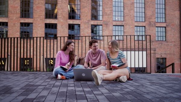 Group of generation Z students studying together outdoors after school. Young stylish zoomers working together on school project, preparing a presentation. Concept of power of friendship and importance of education of gen Z.