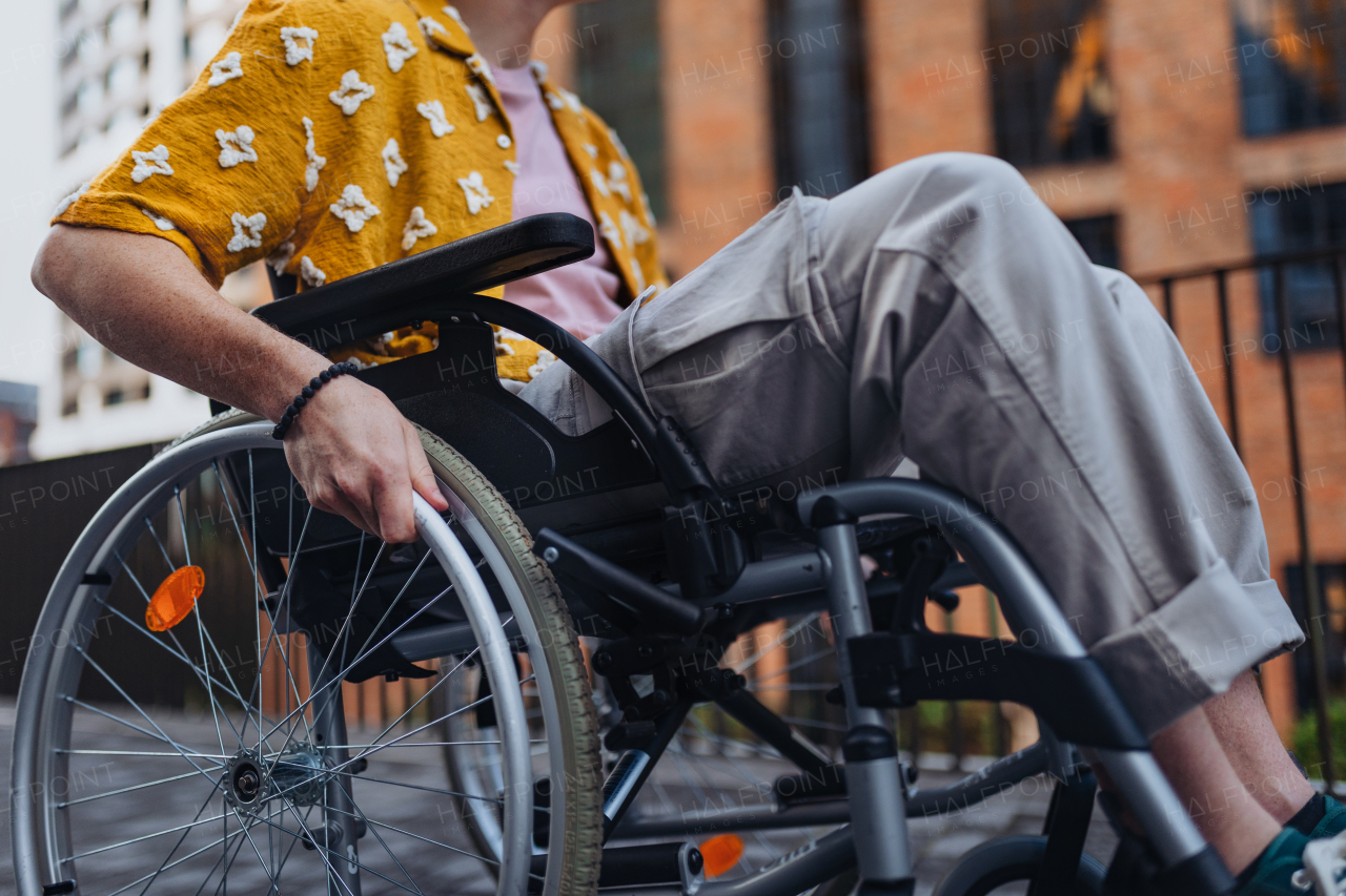 Close up of young Gen Z boy in a wheelchair in the city. Inclusion, equality, and diversity among Generation Z people.