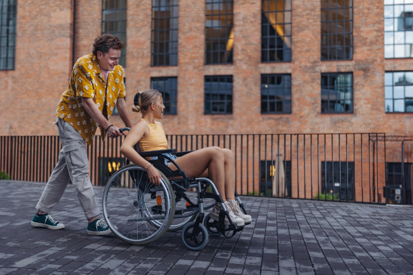 Beautiful gen Z girl in a wheelchair with her boyfriend. Inclusion, equality, and diversity among Generation Z.