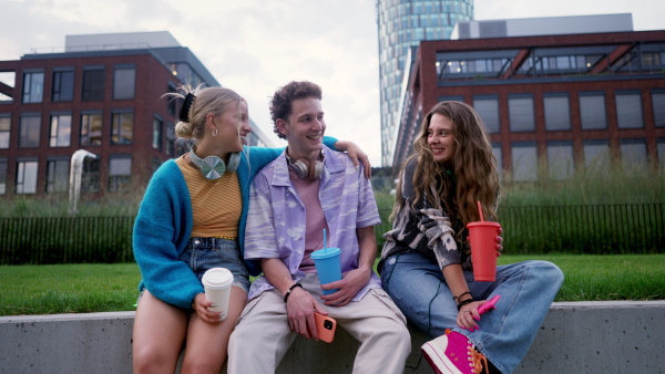 Generation z students hanging out together outdoors in the city. Young stylish zoomers are online, using smartphones, social media, taking selfies. Concept of power of friendship and social strength of gen Z.