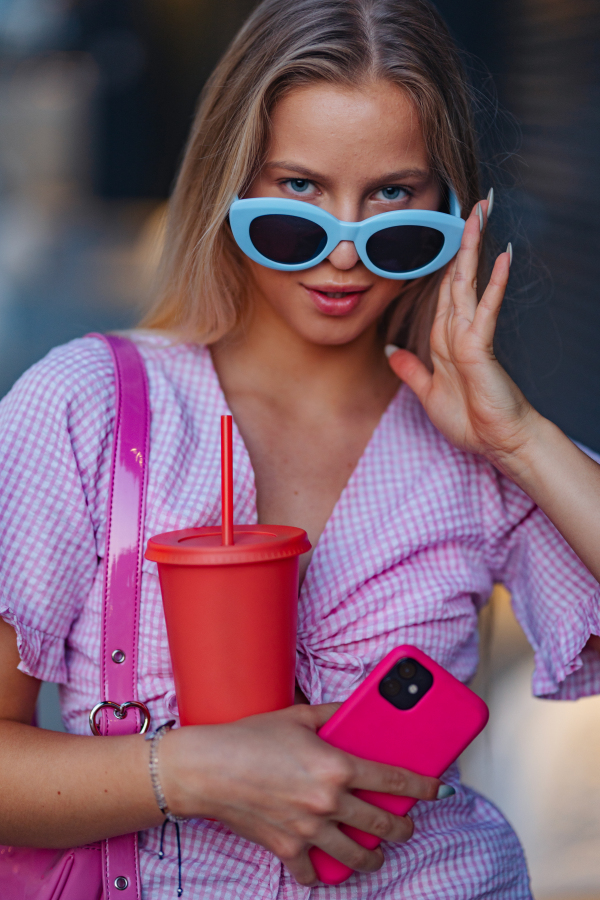 Portrait of gen Z girl in pink outfit before going the cinema to watch movie. The young zoomer girl watched a movie addressing the topic of women, her position in the world, and body image.