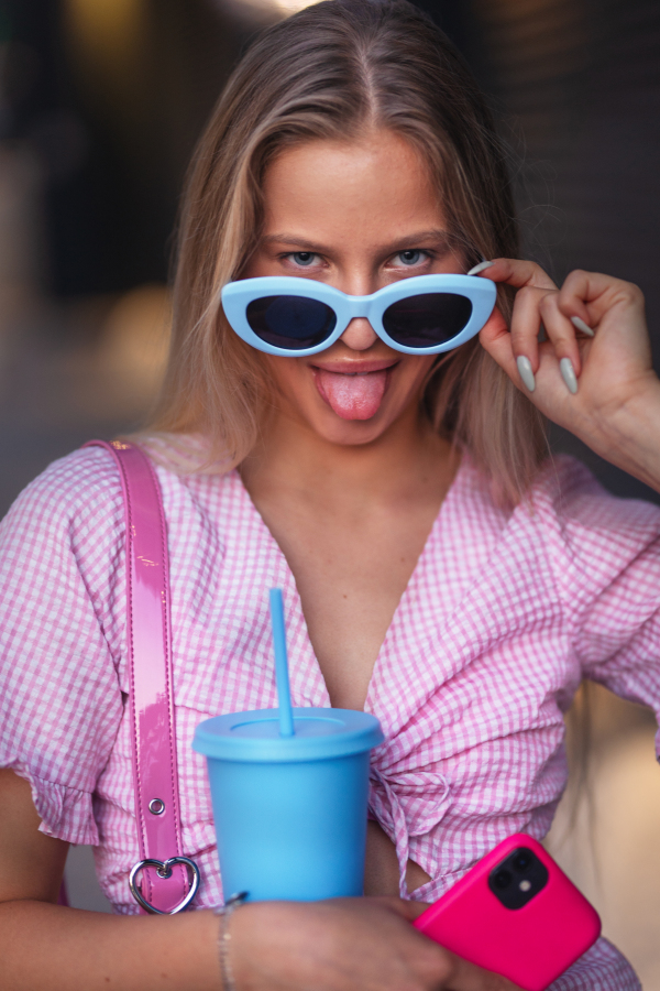 Portrait of gen Z girl in pink outfit before going the cinema to watch movie. The young zoomer girl watched a movie addressing the topic of women, her position in the world, and body image.