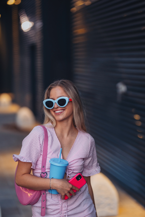 Portrait of gen Z girl in pink outfit before going the cinema to watch movie. The young zoomer girl watched a movie addressing the topic of women, her position in the world, and body image.