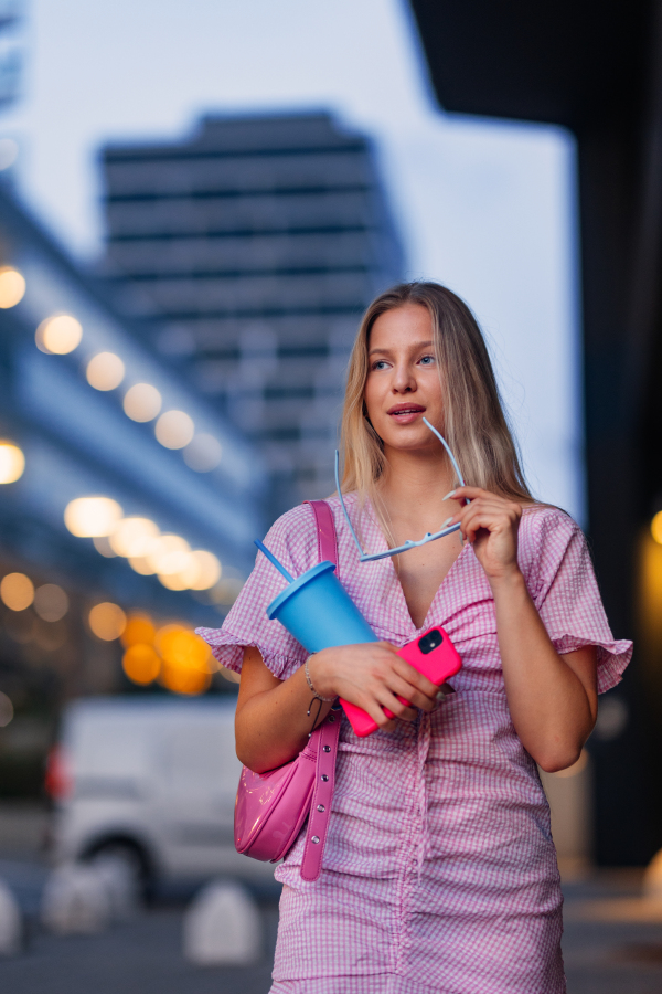 Portrait of gen Z girl in pink outfit before going the cinema to watch movie. The young zoomer girl watched a movie addressing the topic of women, her position in the world, and body image.