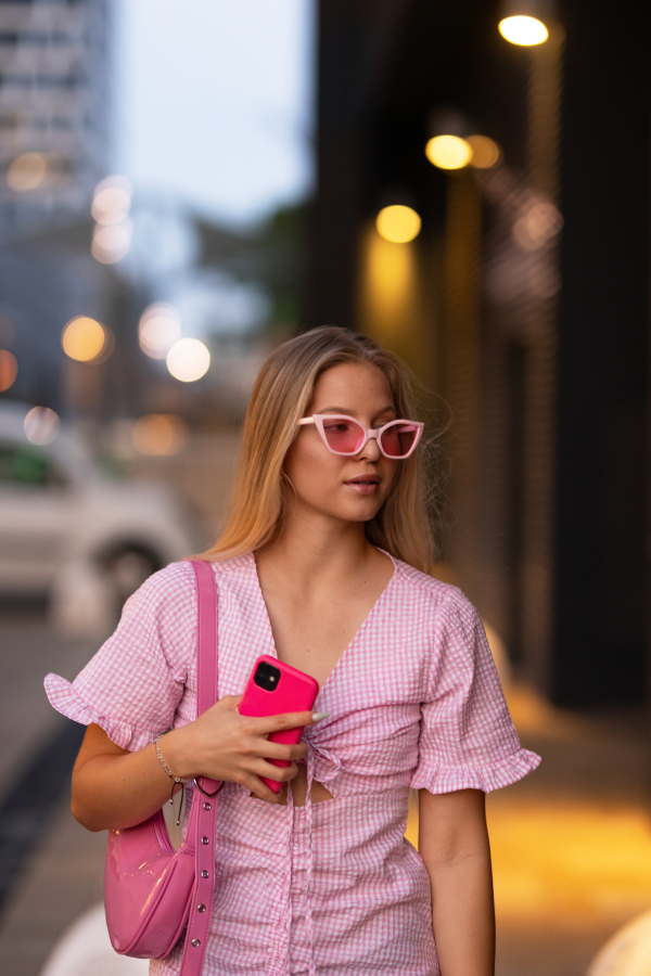 Portrait of gen Z girl in pink outfit before going the cinema to watch movie. The young zoomer girl watched a movie addressing the topic of women, her position in the world, and body image.