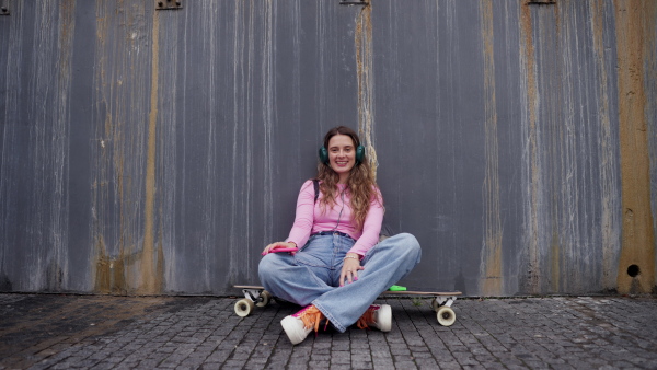 Video of generation z girl student sitting outdoors in the city. Student spending free time online and alone. Concept of gen Z as loneliest generation.