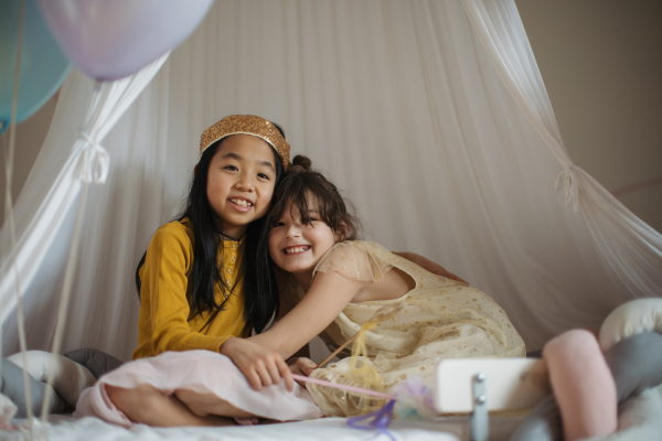 Happy girls playing on princess in room.