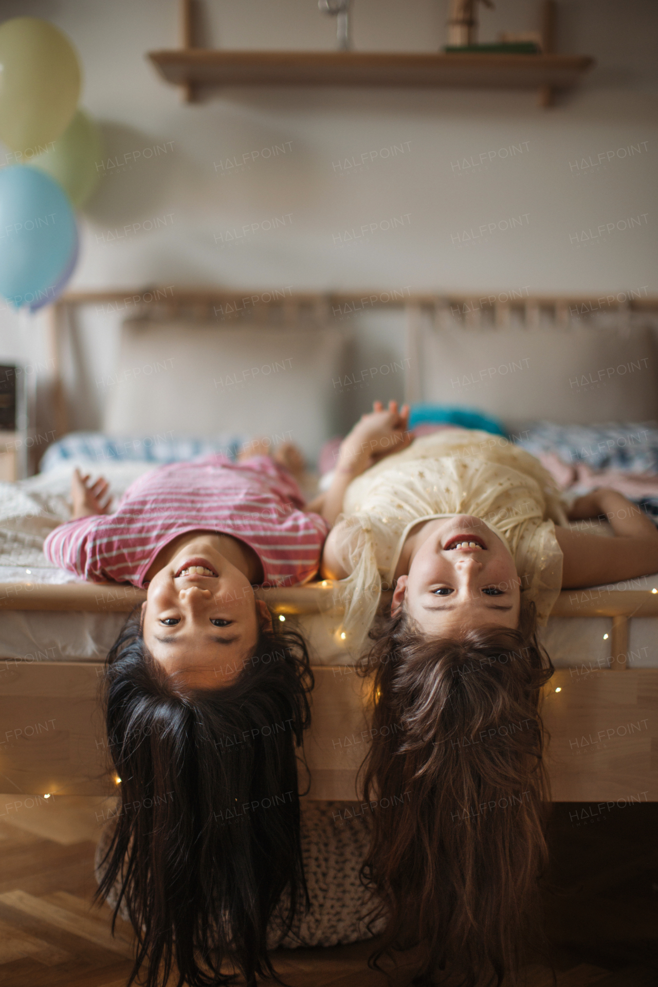 Happy children, friends lying on the bed.