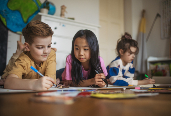 Happy friends drawing together in the room.