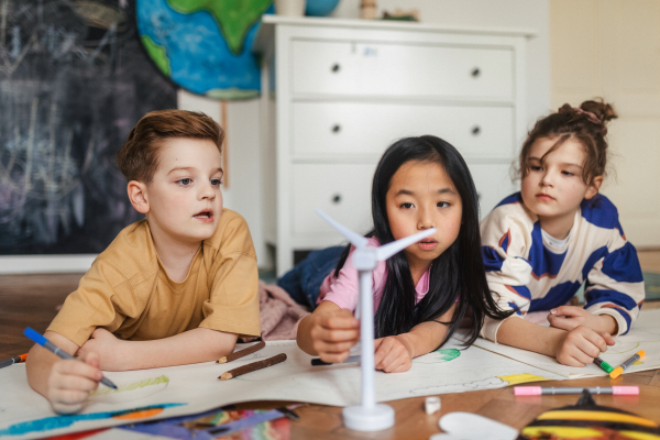 Happy friends drawing together in the room.