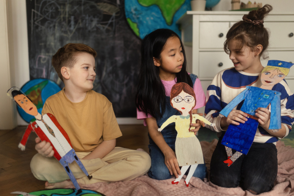 Little children playing with beautiful handmade puppets.