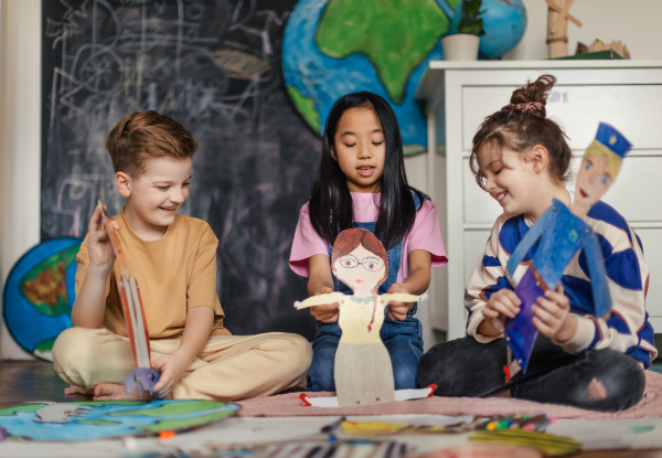 Little children playing with beautiful handmade puppets.