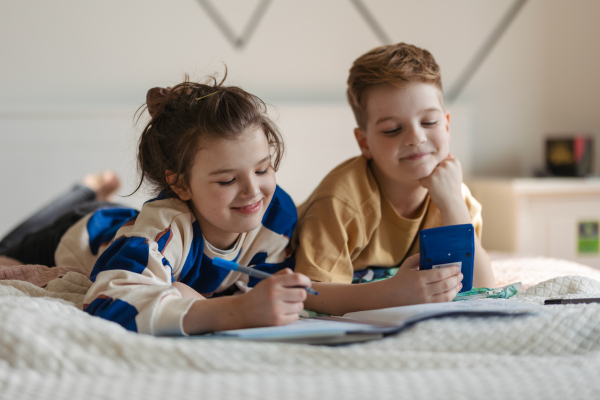 Sister and brother learing together. Happy friends having fun and do the math homework together.