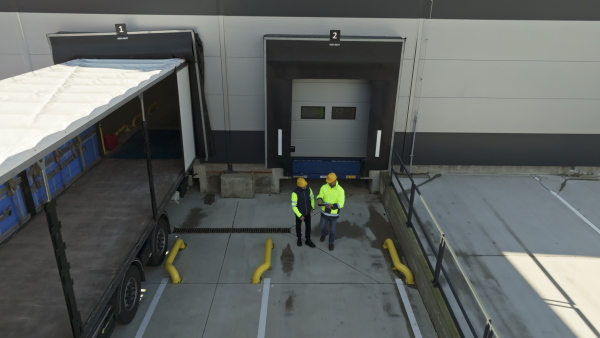 A top view of warehouse receivers unloading of the truck in front of warehouse, checking delivered items.