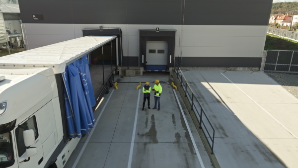 A top view of warehouse receivers unloading of the truck in front of warehouse.