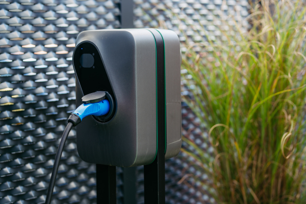 Close up electric car charging station in front of the office building. Charging at work, workplace.