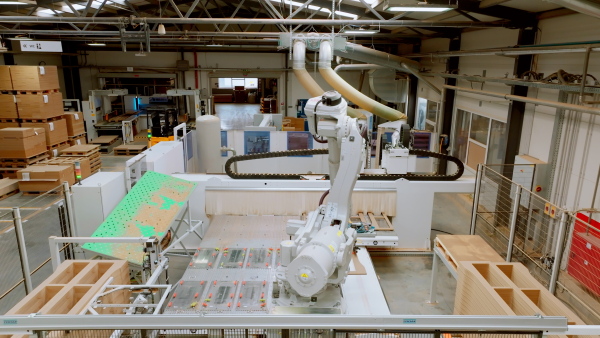 Industrial automation and robotics in modern industrial factory. Advanced, high precision robotic arm assembling wooden furniture in big furniture manufacturing facility with robotic arms and automation.