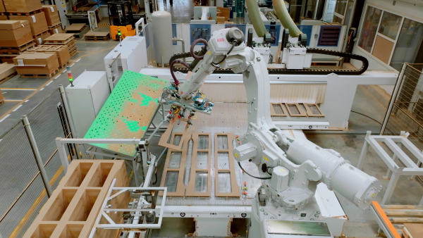 Industrial automation and robotics in modern industrial factory. Advanced, high precision robotic arm assembling wooden furniture in big furniture manufacturing facility with robotic arms and automation.