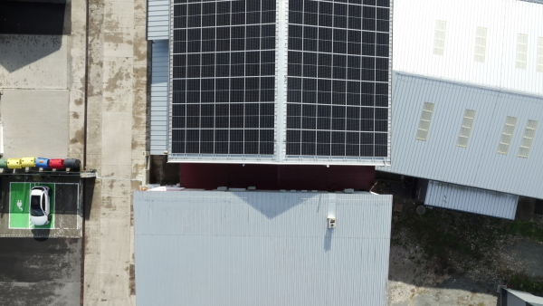 Aerial view of a solar panels on rooftop of factory. Solar energy as renewable energy source in business.