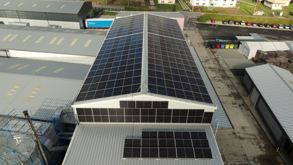 Aerial view of a solar panels on rooftop of factory. Solar energy as renewable energy source in business.