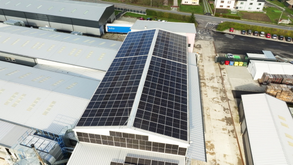 Aerial view of a solar panels on rooftop of factory. Solar energy as renewable energy source in business.