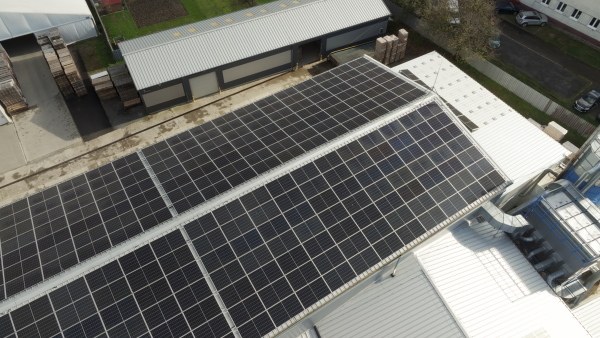 Aerial view of a solar panels on rooftop of factory. Solar energy as renewable energy source in business.