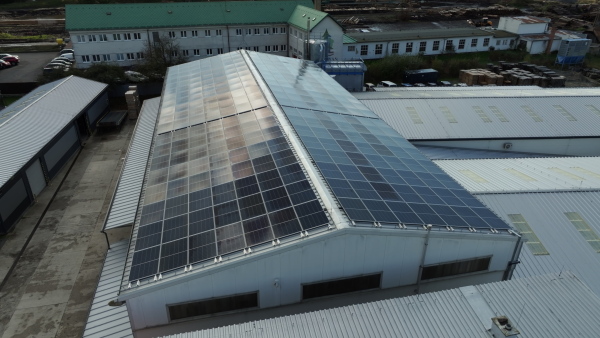 Aerial view of a solar panels on rooftop of factory. Solar energy as renewable energy source in business.