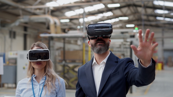 Warehouse managers talking logistics using VR, controlling stock levels, discussing shipping process. Virtual reality in inventory management. Smart glasses guiding managers through warehouse, recording tracking data and quicken picking process.