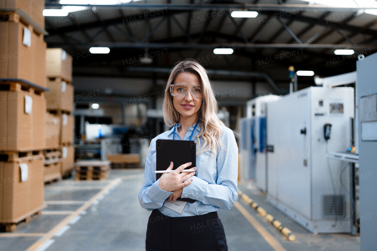 Portrait of female manager standing in modern industrial factory. Manufacturing facility with robotics and automation. Female leader, CEO in heavy industry, manufactury.