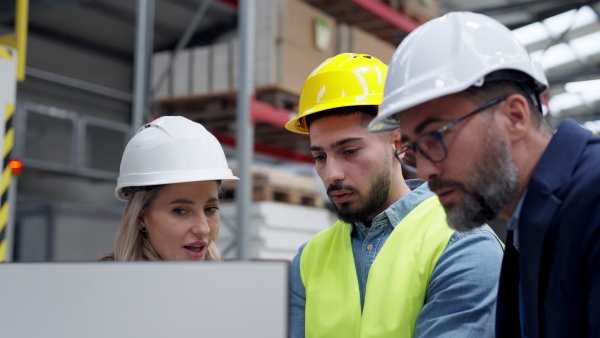 Female engineer, foreman consulting with director in modern industrial factory, talking about new production project, investment. Team management in manufacturing facility.