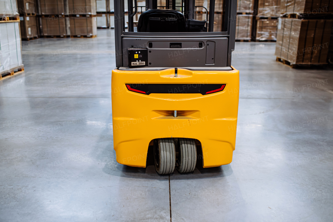 Forklift in warehouse in the middle of stored goods. Forklift driver preparing products for shipmennt, delivery, checking stock in the warehouse.