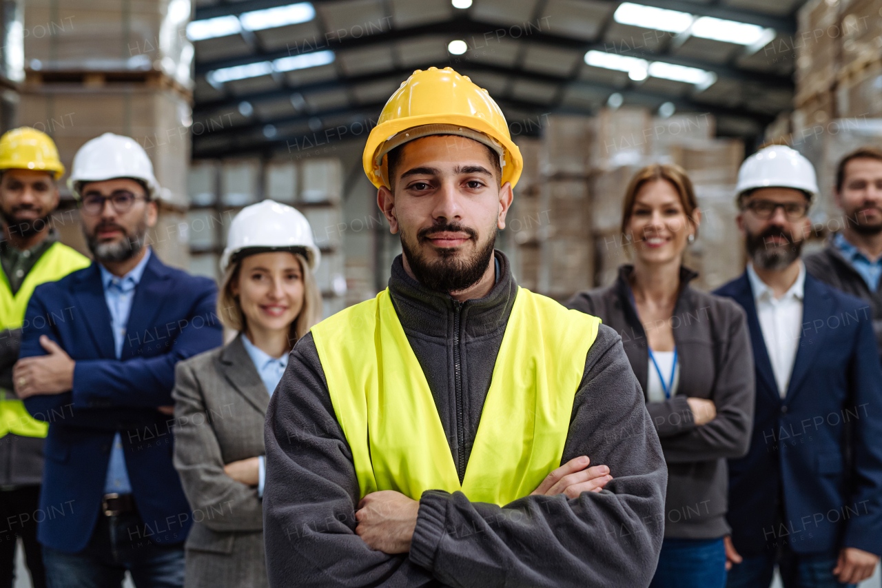 Full team of warehouse employees standing in warehouse. Team of workers, managers and female director in modern industrial factory, heavy industry, manufactrury. Group portrait.