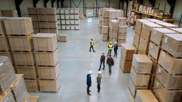 A top view of warehouse workers in warehouse. Team of warehouse workers preparing products for shipment, checking delivery, stock in warehouse building.