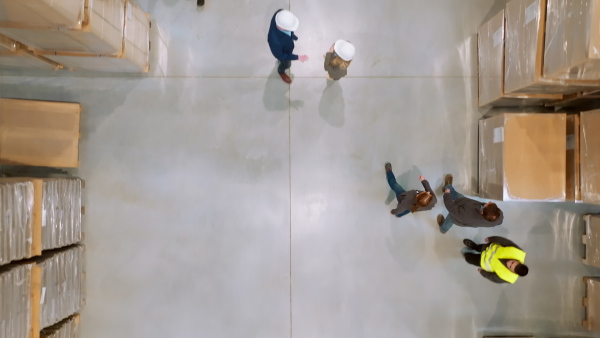 A top view of warehouse workers in warehouse. Team of warehouse workers preparing products for shipment, checking delivery, stock in warehouse building.