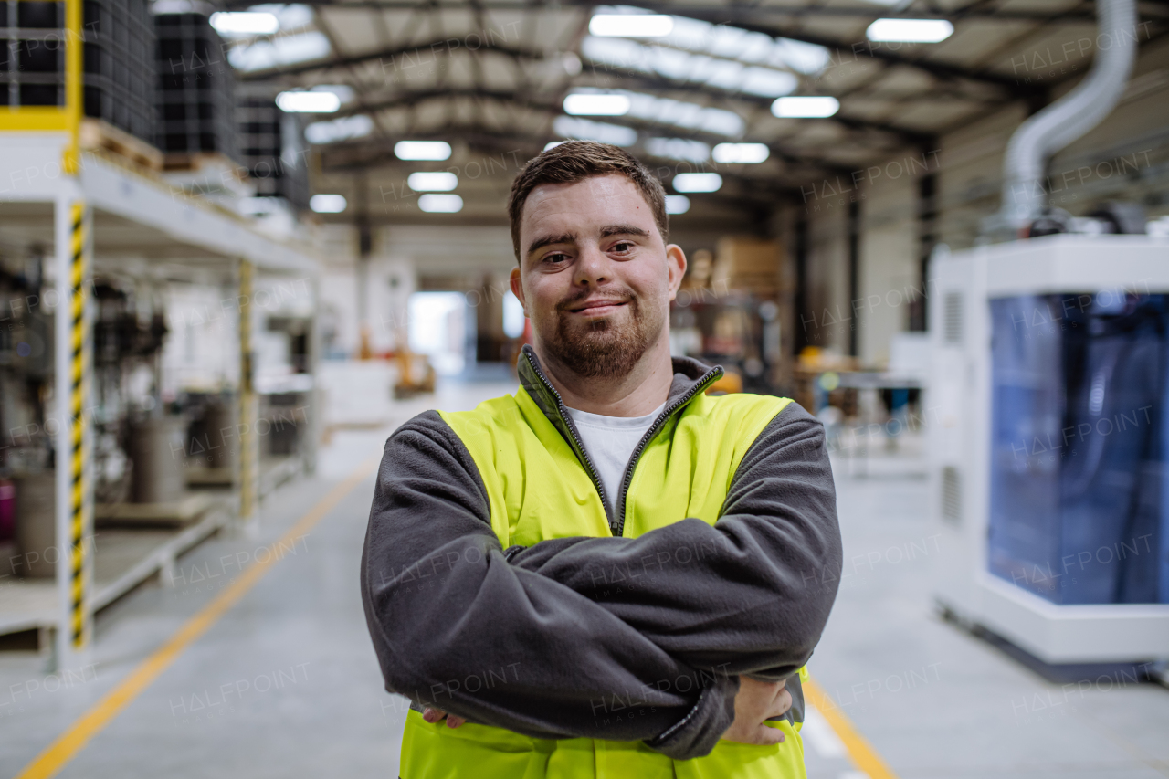 Young man with Down syndrome working in warehouse. Concept of workers with disabilities, support in workplace.