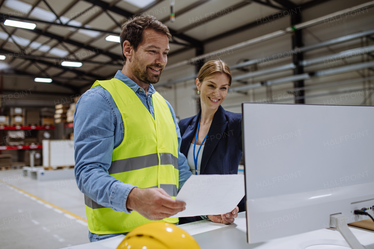 Female warehouse director talking with production manager, discussing new order, preparing products for shipment, delivery, checking stock in the warehouse.