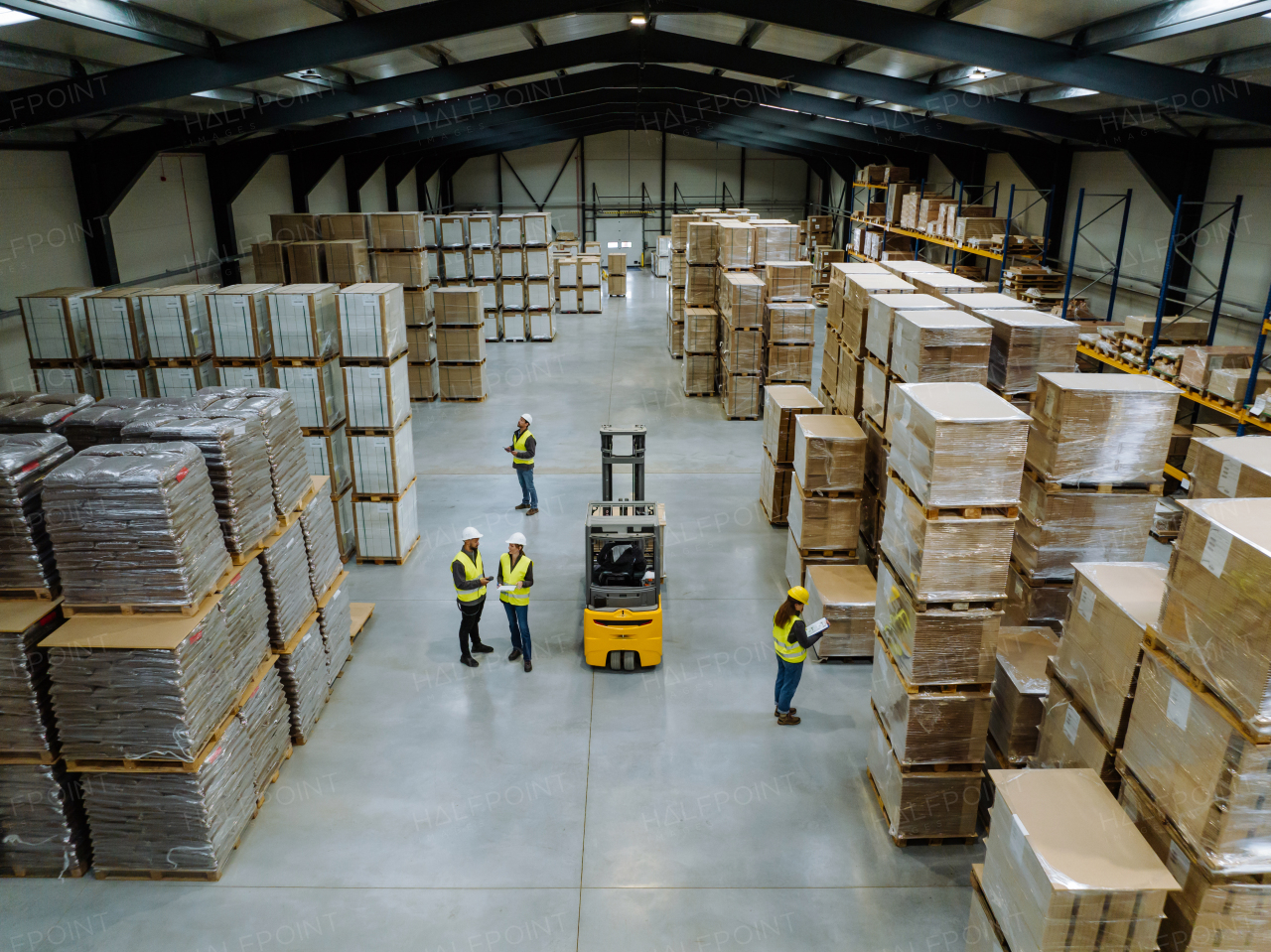 Top view of warehouse workers in warehouse. Team of warehouse workers preparing products for shipment, checking delivery, stock in warehouse building.