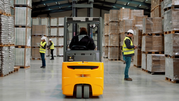 A full team of warehouse employees walking in warehouse. Team of workers, managers and female director in modern industrial factory, heavy industry, manufactrury. Group portrait.